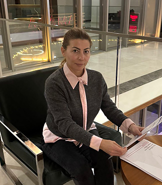 Stanislava Dolapchieva, Director of InNeed Recruit, is seated in a chair, professionally holding documents and exuding leadership in the team members section of the website.